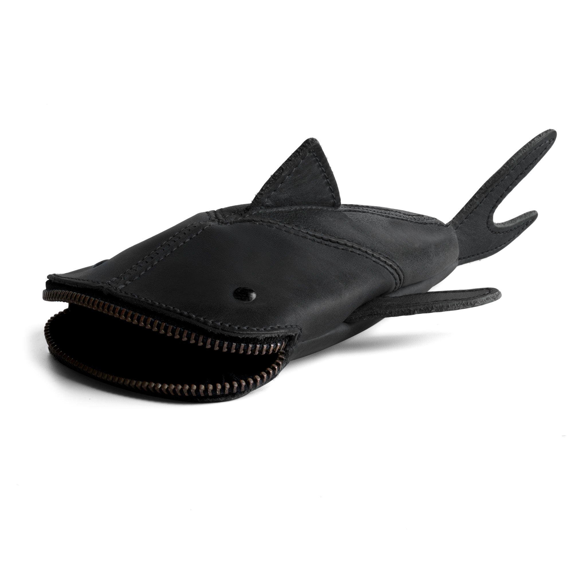 Stylish Leather Shark Pouch by Hide & Drink, showcasing a sleek zippered design. This shark shaped case, perfect for storing change or cables, is made from durable full grain leather. Ideal as a pencil purse or stuffed animal accessory, it represents artisan craftsmanship handmade in La Antigua Guatemala & Oaxaca Mexico, featuring small batch production and hand sewn details.