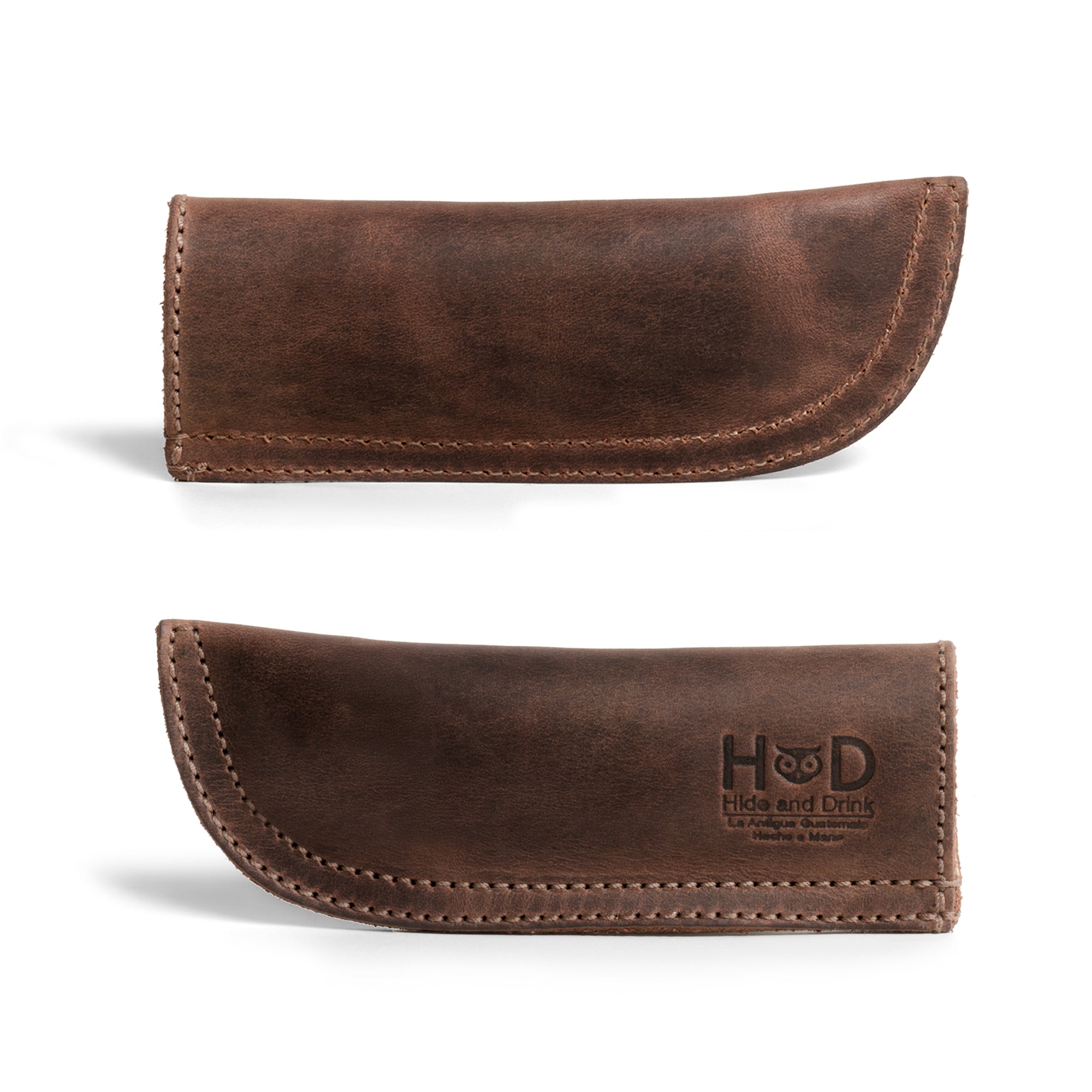 Hide & Drink Cast Iron Panhandle Cover dramatically displayed, emphasizing its unique design. This artisan hot handle protector blends full grain leather craftsmanship with practicality, featuring double stitching for durability. Handmade in La Antigua Guatemala & Oaxaca Mexico, it's perfect for adding a stylish touch to your cooking.