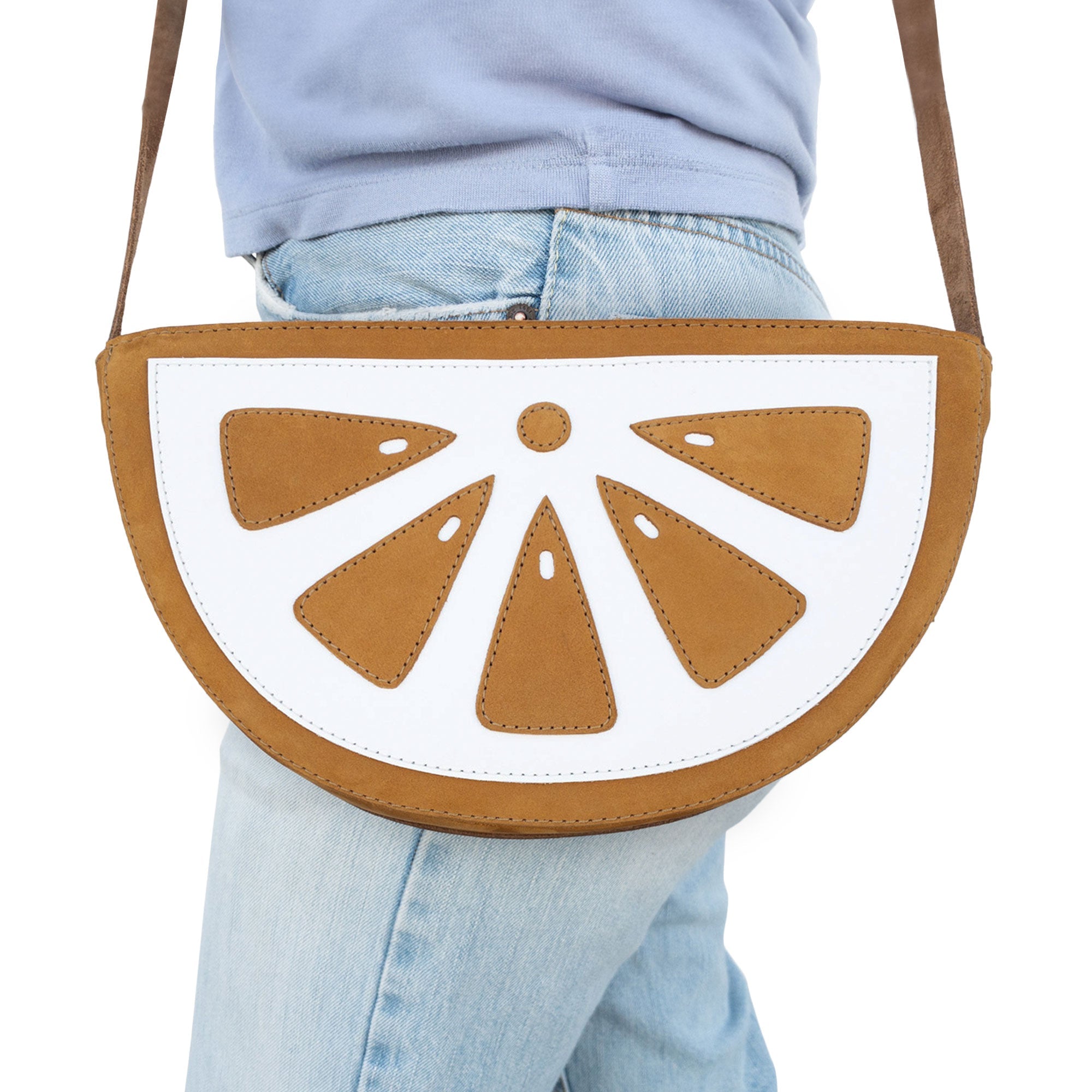 Model carrying the Lemon-Shaped Shoulder Bag by Tudi Frudi, highlighting its fashionable design while worn. This Lemon-Shaped Shoulder Bag with Adjustable Strap serves as a perfect Messenger Bag or Vintage Purse. Crafted from Full Grain Leather, it embodies Small Batch Production, and artisanal quality with hand cut and hand sewn details by artisans in La Antigua Guatemala & Oaxaca Mexico.