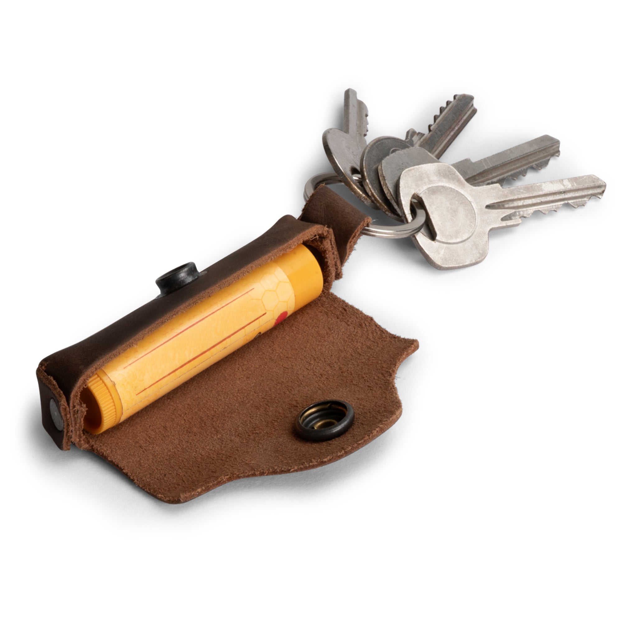Heather's Lip Balm Keychain - A sleek Lip Balm Keychain Holder handmade from Full Grain Leather. Perfect for carrying your favorite lip balm, this travel and carry on lips protection pocket snap case makes a great gift for commuters and nomads. Crafted in La Antigua Guatemala with small batch production, hand cut and sewn techniques, this artisan piece features fire branded detailing.