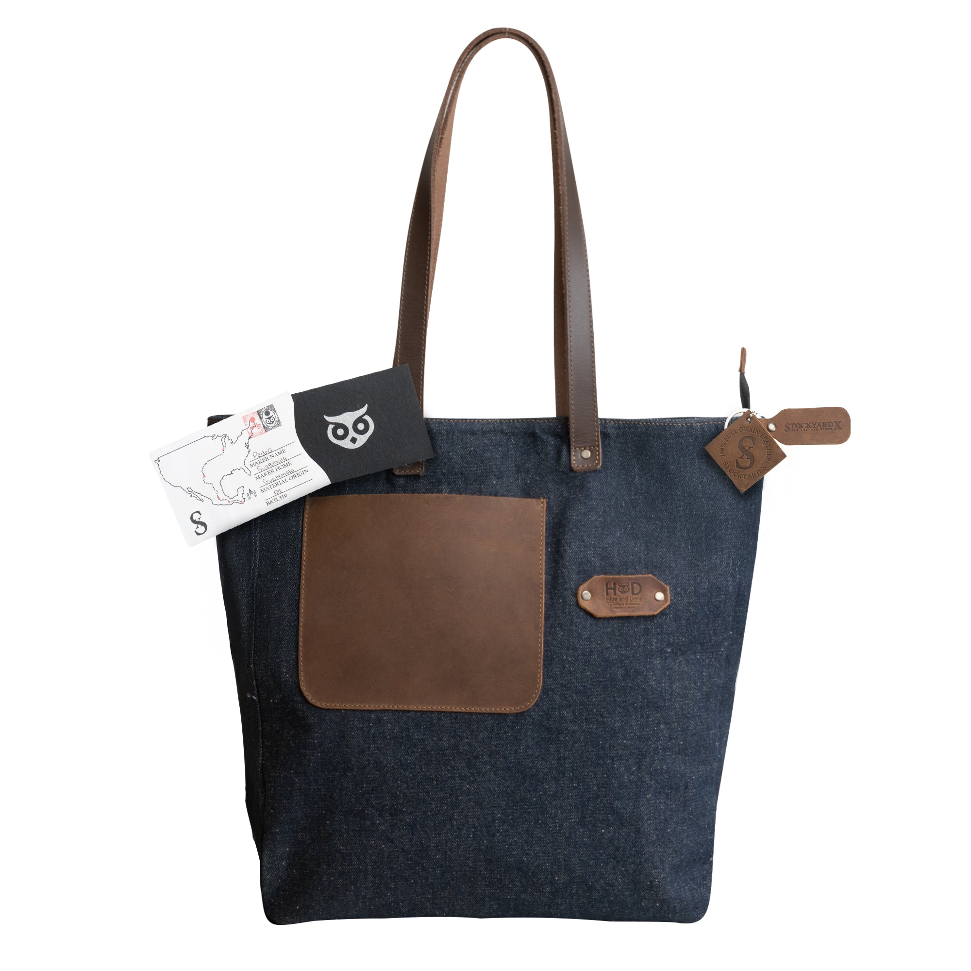 Denim Tote Bag with Leather Straps by Hide & Drink with brand tags and accessories displayed for showcasing premium craftsmanship. Durable Denim Tote Bag with Leather Straps, Cell Phone Purse, Shoulder Bag for Girls, Full Grain Leather, StockyardX, Small Batch Production, Hand Cut, Hand Sewn, Fire Branded, Artisan, Handmade in La Antigua Guatemala & Oaxaca Mexico.