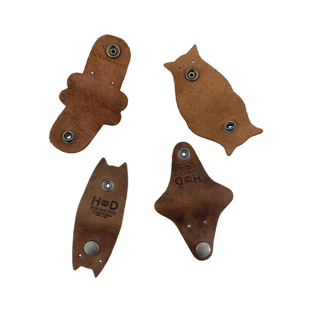 Furry Friends Cord Keeper (4-Pack), featuring delightful animal shapes, made of durable full grain leather by Hide & Drink, great for organizing cords. Furry Friends 4-Pack Cord Keeper (Cord Clam), Full Grain Leather, StockyardX, Small Batch Production, Hand Cut, Hand Sewn, Fire Branded, Artisan, Handmade in La Antigua Guatemala & Oaxaca Mexico.