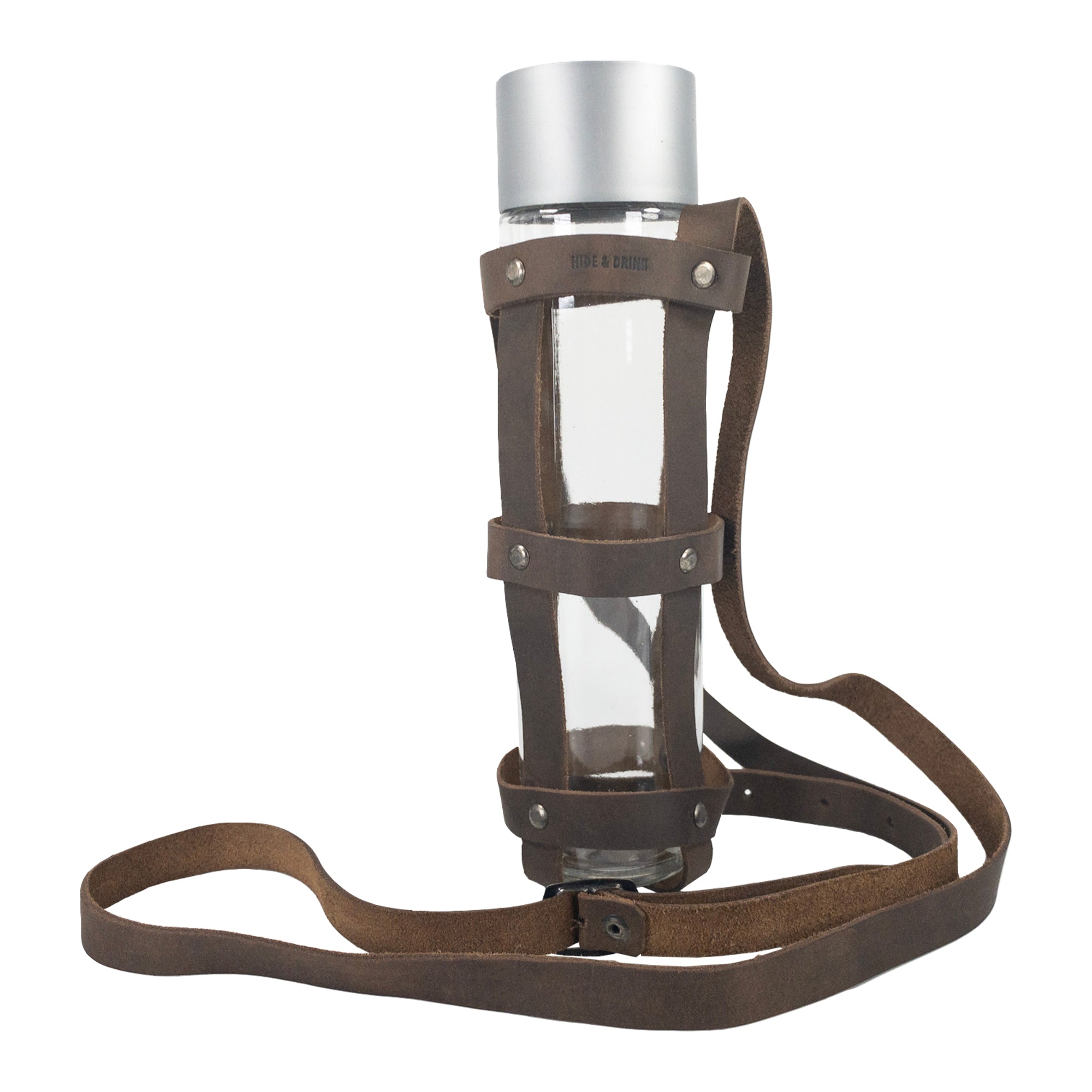 Hide & Drink’s Riveted Bottle Carrier (Bottle Included) showcasing a stylish design made of full grain leather. This travel accessory is perfect for carrying your glass bottle on the go, handcrafted with care in La Antigua Guatemala & Oaxaca Mexico. Riveted Long Bottle Carrier (Glass Bottle Not Included), made using small batch production, hand cut, hand sewn, and fire branded by artisans.