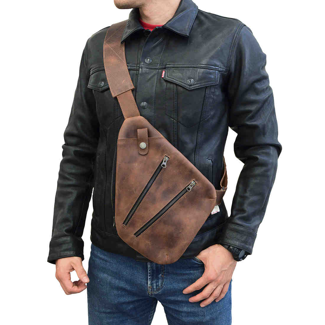 A person wearing the Kidney Shoulder Bag by Hide & Drink, highlighting its fashionable design as an Everyday Crossbody Bag made from Full Grain Leather. This artisan bag exemplifies small batch production with hand cut, hand sewn craftsmanship, proudly made in La Antigua Guatemala & Oaxaca Mexico.