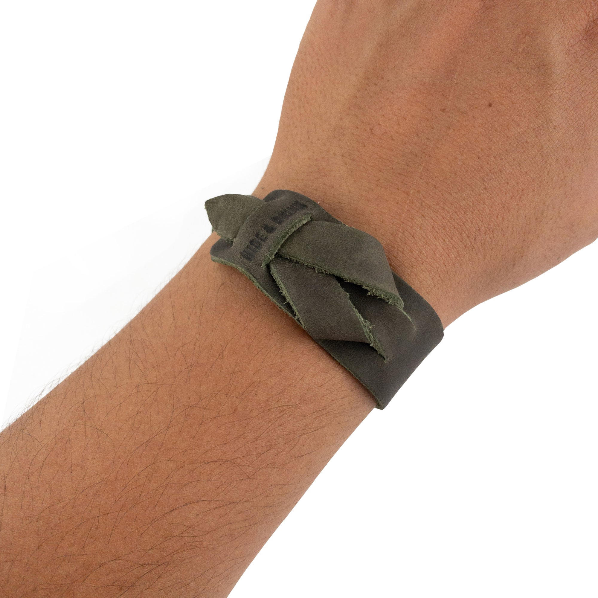 Hide & Drink's Minimalist Wristband worn showing its earthy green color and handmade craftsmanship. This stylish cuff is made from full grain leather with an adjustable strap, embodying the rustic elegance of artisan products from StockyardX in La Antigua Guatemala.