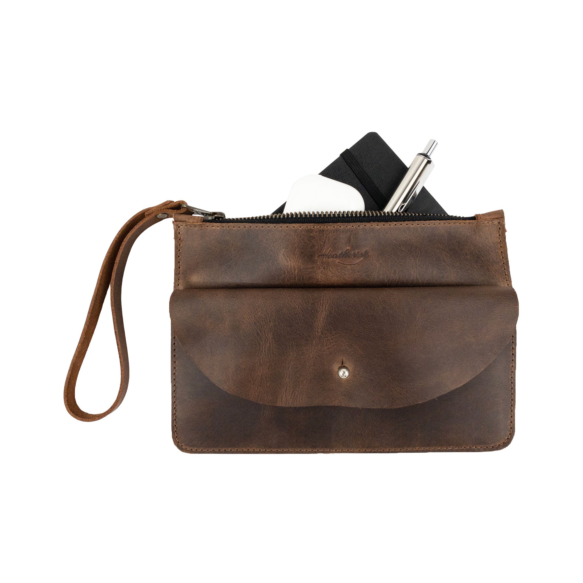 Front view of Heather's Clutch Bag with Extra Pouch, holding everyday items. This Full Grain Leather accessory serves as a stylish wrist wallet for cards, reflecting the artisan skills and handmade quality found in La Antigua Guatemala & Oaxaca Mexico.